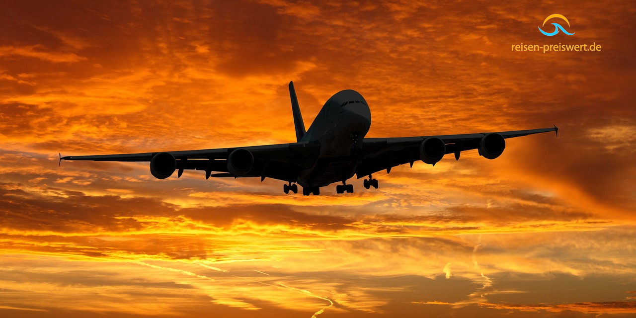 Ein großes Flugzeug am Abendhimmel. Der Himmel ist orange