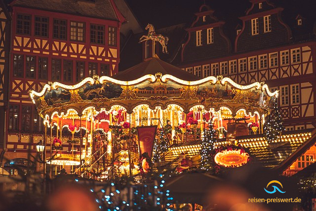 Frankfurter Weihnachtsmarkt im Dunkeln. In der Mitte ein romantisch beleuchtetes Pferdekarussell. Im Hintergrund Fachwerkhäuser