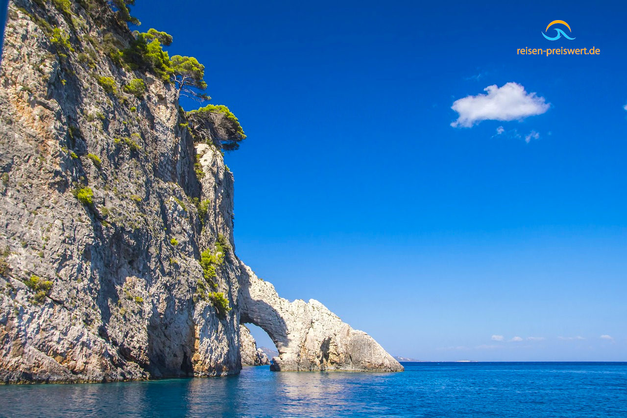 Steile Felsformationen am Strand von Zakynthos (Griechenland). An den Felsen wachsen Bäume. Unterspülungen und Höhlen sind zu erkennen