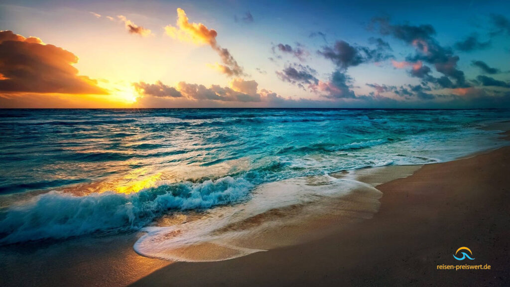 Sonnenuntergang am Strand. Die Wellen treffen in der Dämmerung auf den feinsandigen Strand