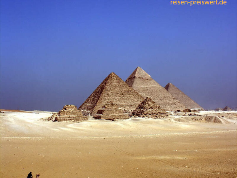 Die Pyramiden in der Wüste von Ägypten. Im Vordergrund ein Kamel. Der Himmel ist strahlend blau