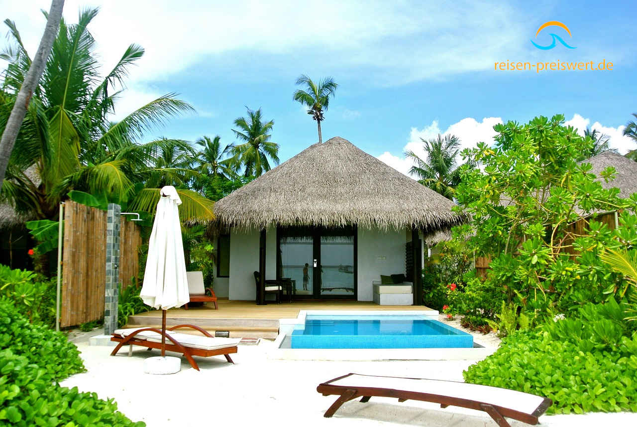 Strandvilla mit Palmendach und privatem Pool am weißen Sandstrand auf den Malediven, umgeben von Palmen